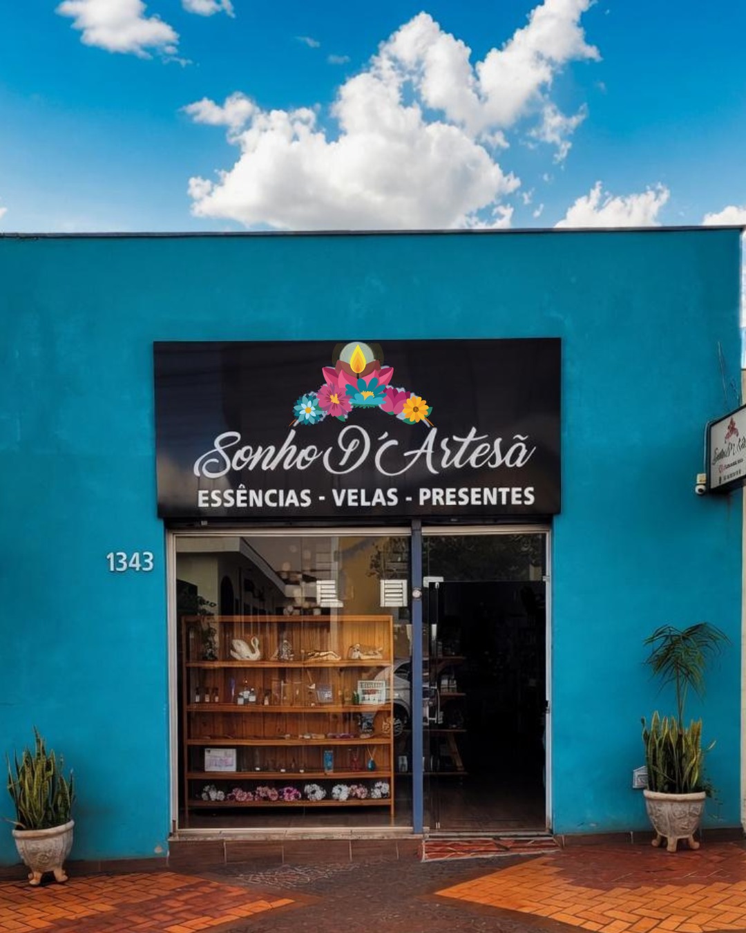 Fachada turquesa da loja Sonho D’Artesã em Sertãozinho, com a placa Essências, Velas e Presentes